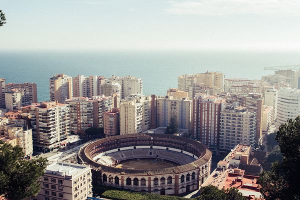 ESAGP Malaga round stadium surrounded by buildings near the sea Christian Moller.jpg
